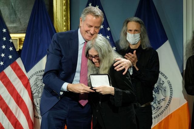Bill de Blasio hugs Patti Smith as he presents her the key to NYC